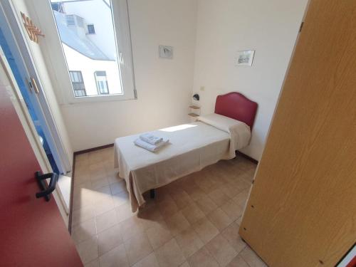 mały pokój z łóżkiem i oknem w obiekcie HOTEL IDEALE young people under 40 w Rimini