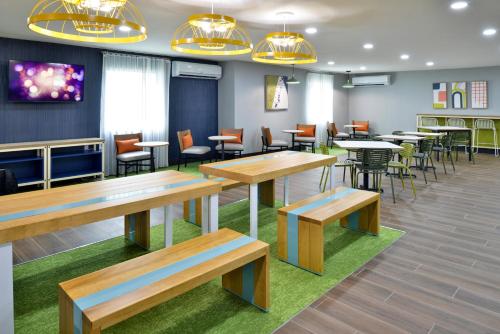 a restaurant with wooden tables and chairs and tablesktop at Spark By Hilton Dallas Medical District Love Field in Dallas