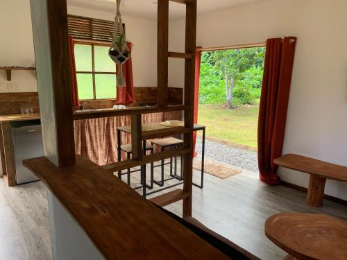 a room with a room with a table and a window at Fare lei , bungalow en toute simplicité in Uturoa