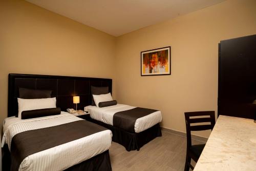 a hotel room with two beds and a table at Hotel San Francisco in San Luis Potosí