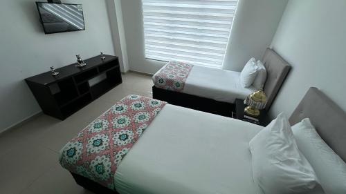 a hotel room with two beds and a sink at Rio-ApartaHotel-Lagos in Leticia