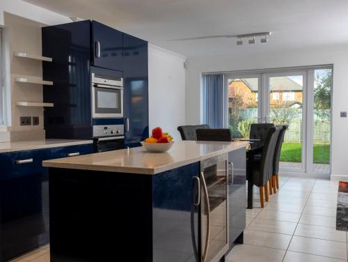 a kitchen with black cabinets and a bowl of fruit on the counter at Supreme Class Properties in Eastchurch