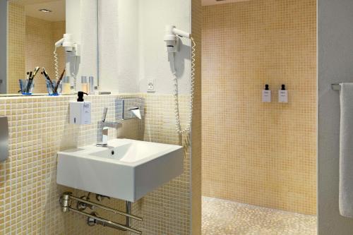 ein Bad mit einem Waschbecken und einer Dusche in der Unterkunft Scandic Front in Kopenhagen