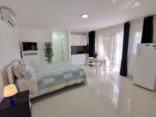 um quarto com uma cama e uma cozinha com um frigorífico em SOL CARIBE SUITES - PLAYA LOS CORALES - beach club, wifi, swimming pool em Punta Cana