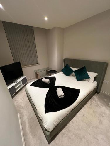 a bedroom with a bed with a black and white blanket at Central Leeds - Modern Spacious Apartment in Leeds