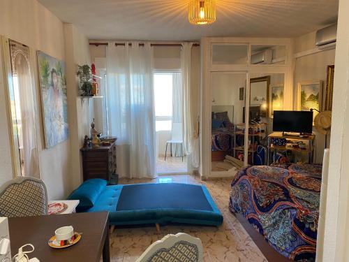 een woonkamer met een blauwe bank in een kamer bij Hercules estudio con vistas al mar in Benalmádena