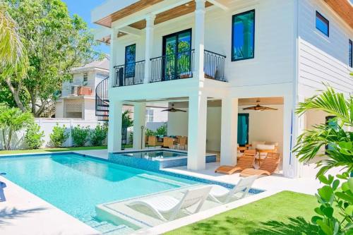a villa with a swimming pool and a house at Tropical Gulf View Estate - Anna Maria, FL in Anna Maria