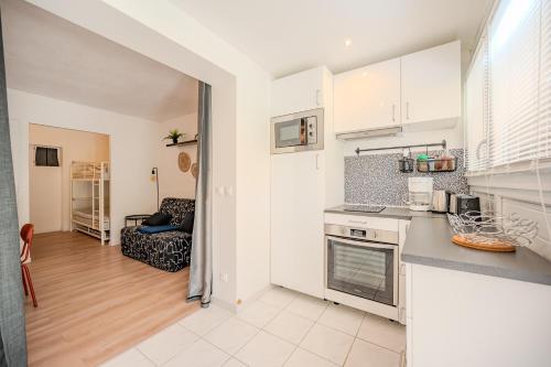 une cuisine avec des armoires blanches et un comptoir dans l'établissement Ty Coz * Cocooning * Paisible * Jardin * Parking, à La Londe-les-Maures