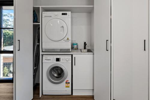 a laundry room with a washing machine and a microwave at Yarra Gables in Healesville