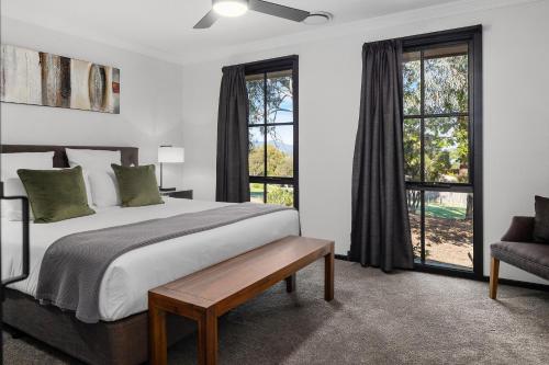 a bedroom with a large bed and windows at Yarra Gables in Healesville