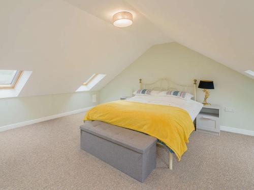 a bedroom with a bed with a yellow blanket on it at 2 Bed in Aberystwyth 83552 in Llanilar