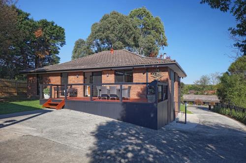 a large brick house with a large deck at Yarra Gables in Healesville