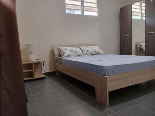 een slaapkamer met een bed met een blauwe matras bij Le T3 de l'Ouest in Saint-Laurent du Maroni