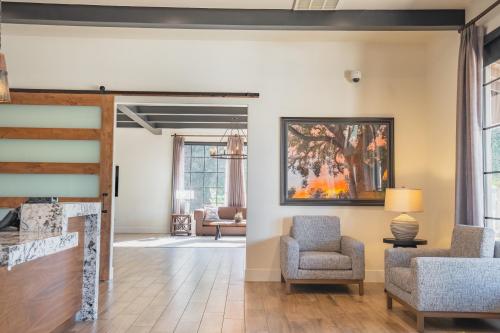 a living room with chairs and a painting on the wall at Riviera Oaks Resort in Ramona