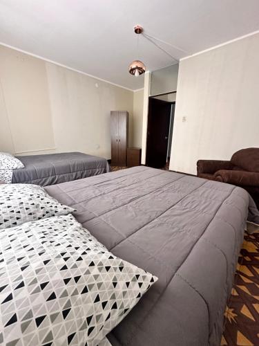 CASTELLARES LA PUEBLA APARTAMENT في اياكوتشو: غرفة نوم بسرير كبير وأريكة