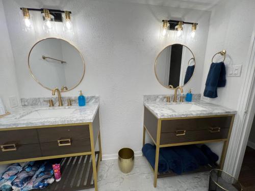 a bathroom with two sinks and two mirrors at The Peacock Cottage in San Marcos