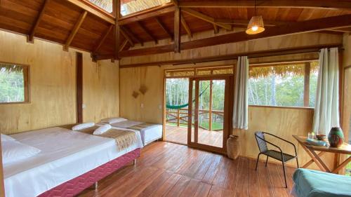 a bedroom with a bed and a table and chairs at Bioma EcoLodge in Iranduba