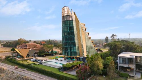 Naka-Raj Escape Hotel في ناخون فانوم: مبنى زجاجي طويل مع مسبح أمام مبنى