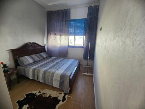 een slaapkamer met een bed en een raam bij Résidence Perla Andaloussia in Mansouria