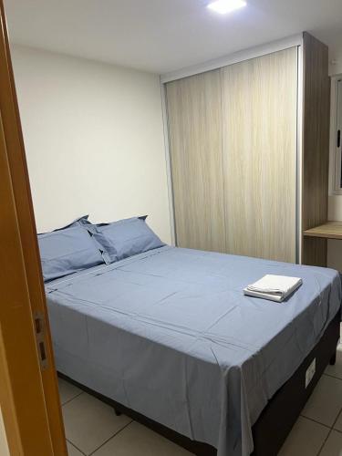a bedroom with a large bed with a blue blanket at Apt Completo no West Flat in Mossoró