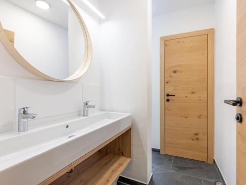 a bathroom with a white sink and a mirror at Lärchenhof Top 202 in Mauterndorf