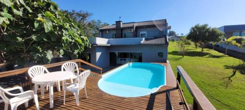 een terras met een zwembad en een tafel en stoelen bij Casa Marinas Boa Vista Pr. in Boa Vista Parecida