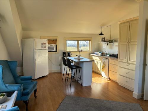 uma cozinha com um frigorífico, uma mesa e cadeiras em Light House Apartment em Brackley Beach