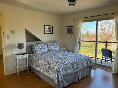 a bedroom with a bed and a large window at Light House Apartment in Brackley Beach