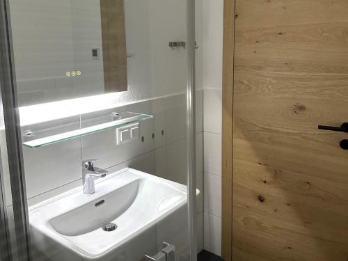 Un baño con un lavabo blanco y un espejo. en Lärchenhof Top 301, en Mauterndorf