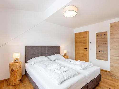 een slaapkamer met een groot bed met witte lakens bij Lärchenhof Top 301 in Mauterndorf