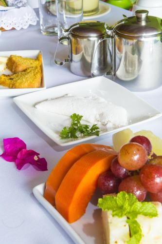 a plate of food with fruit and cheese on a table at Pousada Riacho dos Milagres in São Miguel dos Milagres