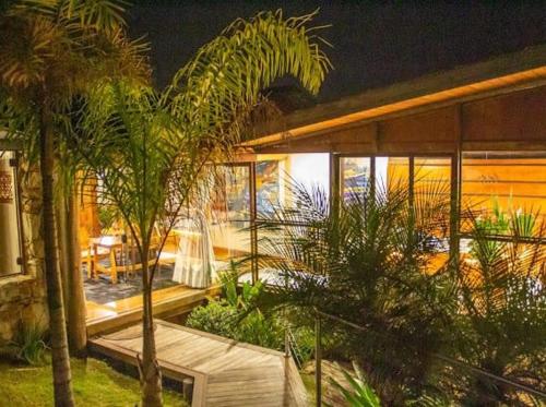 a house with palm trees in front of it at Canto dos Prazeres Lavras Novas in Lavras Novas