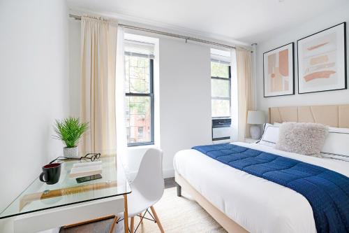 um quarto branco com uma cama e uma mesa de vidro em 444-2C Newly renovated 1BR in Hell's Kitchen em Nova York
