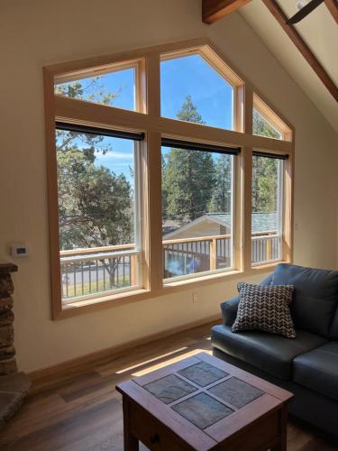 a living room with large windows and a blue couch at HideAway Chalet in Bend