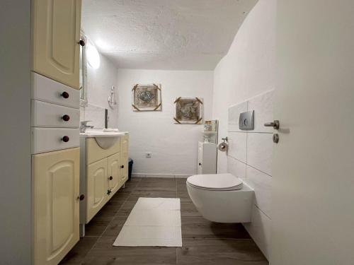 uma casa de banho branca com um WC e um lavatório em Karima em Longkamp