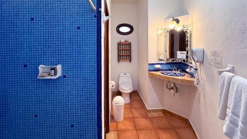 a bathroom with a toilet and a blue tiled shower at Siesta Fiesta Hotel Adults Only - 5th Avenue in Playa del Carmen