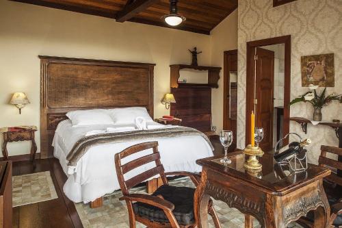 a bedroom with a bed and a table with a desk sidx sidx sidx at Canto dos Prazeres Lavras Novas in Lavras Novas