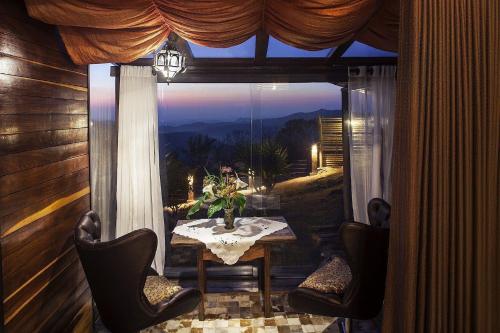 a room with a table and chairs and a large window at Canto dos Prazeres Lavras Novas in Lavras Novas