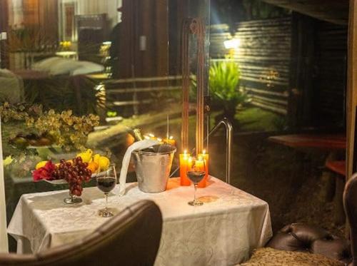 a table with two glasses of wine and flowers on it at Canto dos Prazeres Lavras Novas in Lavras Novas