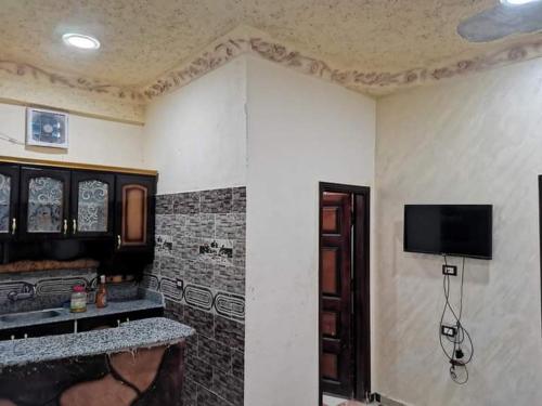 een woonkamer met een tv aan de muur bij غزاله كامب in Siwa