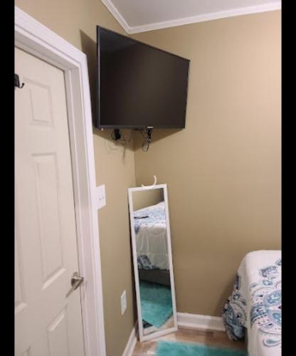 a mirror in a room with a television on the wall at JAMMS tiny home in Baton Rouge