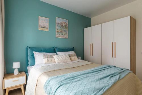 Современные Апартаменты с 2 комнатами : غرفة نوم بسرير كبير بجدار ازرق
