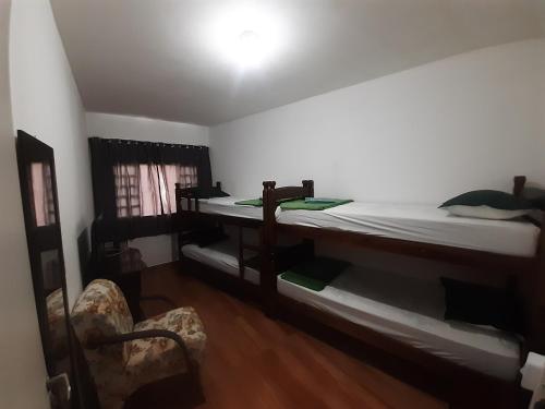 a bedroom with a bed and a desk and a chair at Pousada Malu in Bragança Paulista