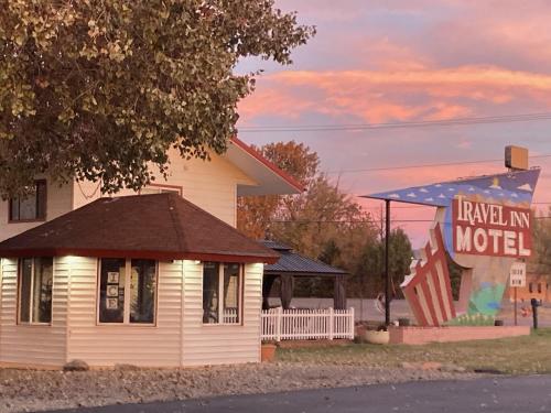 a motel with a sign in front of a building at Travel Inn in Canon City