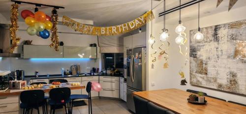 a kitchen with a birthday banner and a table with chairs at דירת 6חדרים אם המושבות in Petaẖ Tiqwa