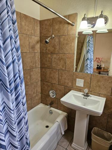 a bathroom with a sink and a bath tub and a sink at Travel Inn Motel in Canon City