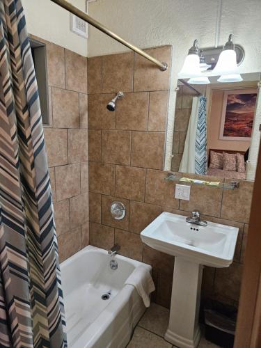 a bathroom with a sink and a bath tub and a sink at Travel Inn in Canon City