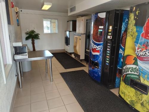 uma sala com duas máquinas de venda automática de refrigerantes e uma mesa em Motel6 em Pendleton