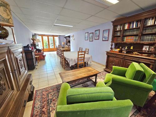 salon z zielonymi krzesłami i stołem w obiekcie Chambres d'Hotes chez Renée w mieście Le Charmel