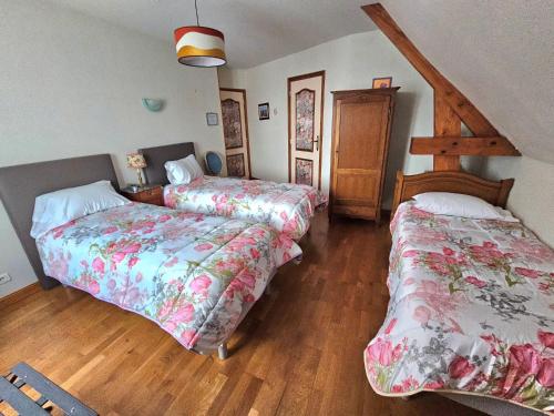 1 dormitorio con 2 camas y suelo de madera en Chambres d'Hotes chez Renée, en Le Charmel